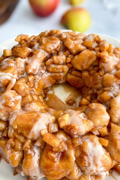 Simple Apple Fritter Monkey Bread with slices of apples in the background