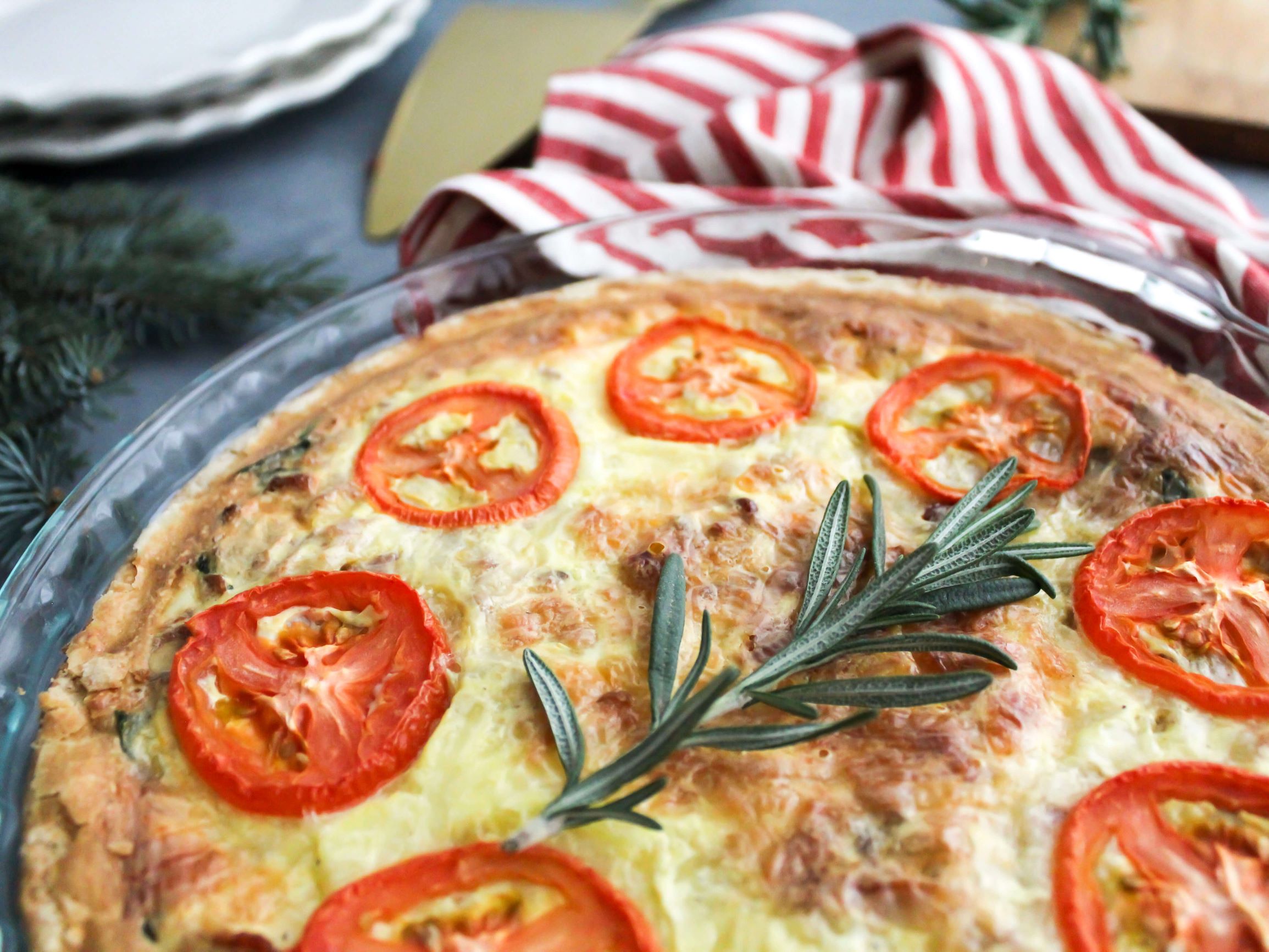 Easy Christmas Morning Quiche with plates and a gold serving piece in the background