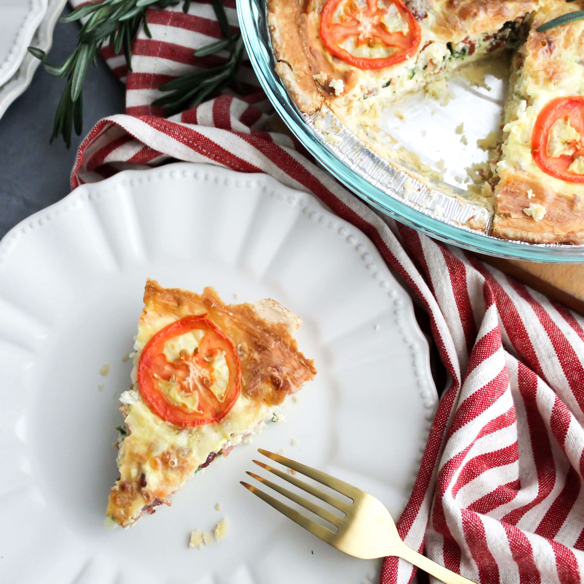 Piece of Christmas Quiche with bacon and spinach and tomatoes plated up