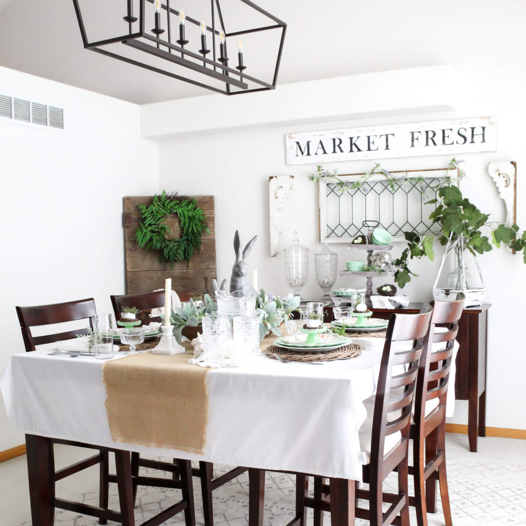 Neutral cottage style dining room decorated for spring with the table set for Easter