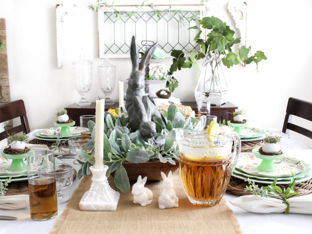 Full view of cottage style dining room decorated for sprign with an Easter tablescape decorated using jadeite dishes and a spring dough bowl centerpiece with bunnies and spring greenery