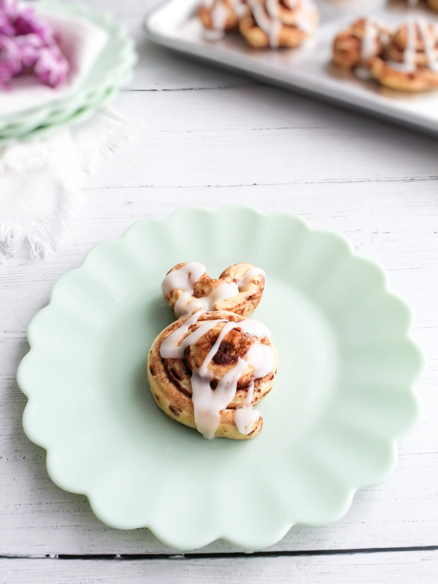 Close up view of frosted Easter bunny cinnamon roll on a plate