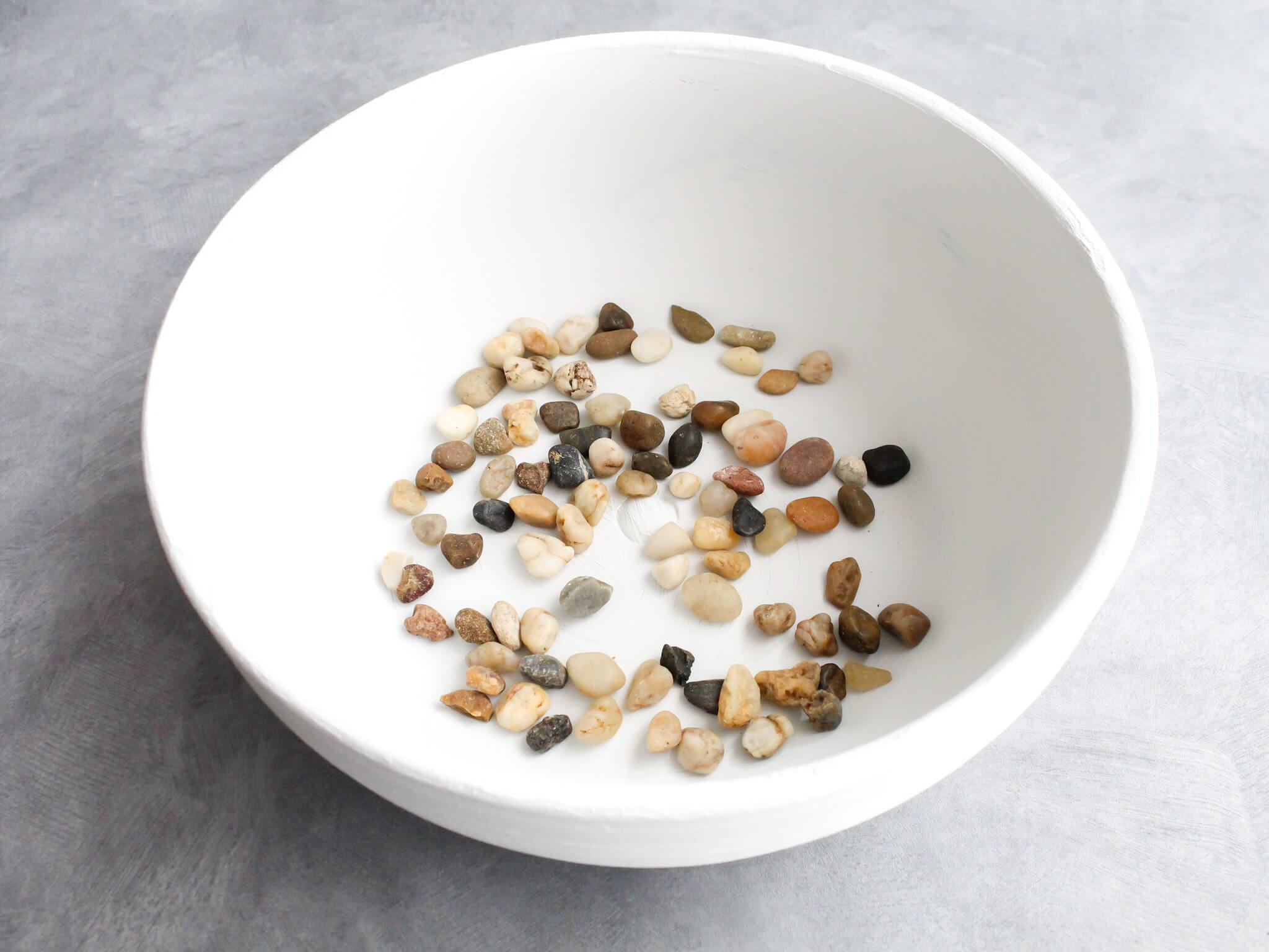 Putting pebbles in the bottom of the aged pot before planting flowers