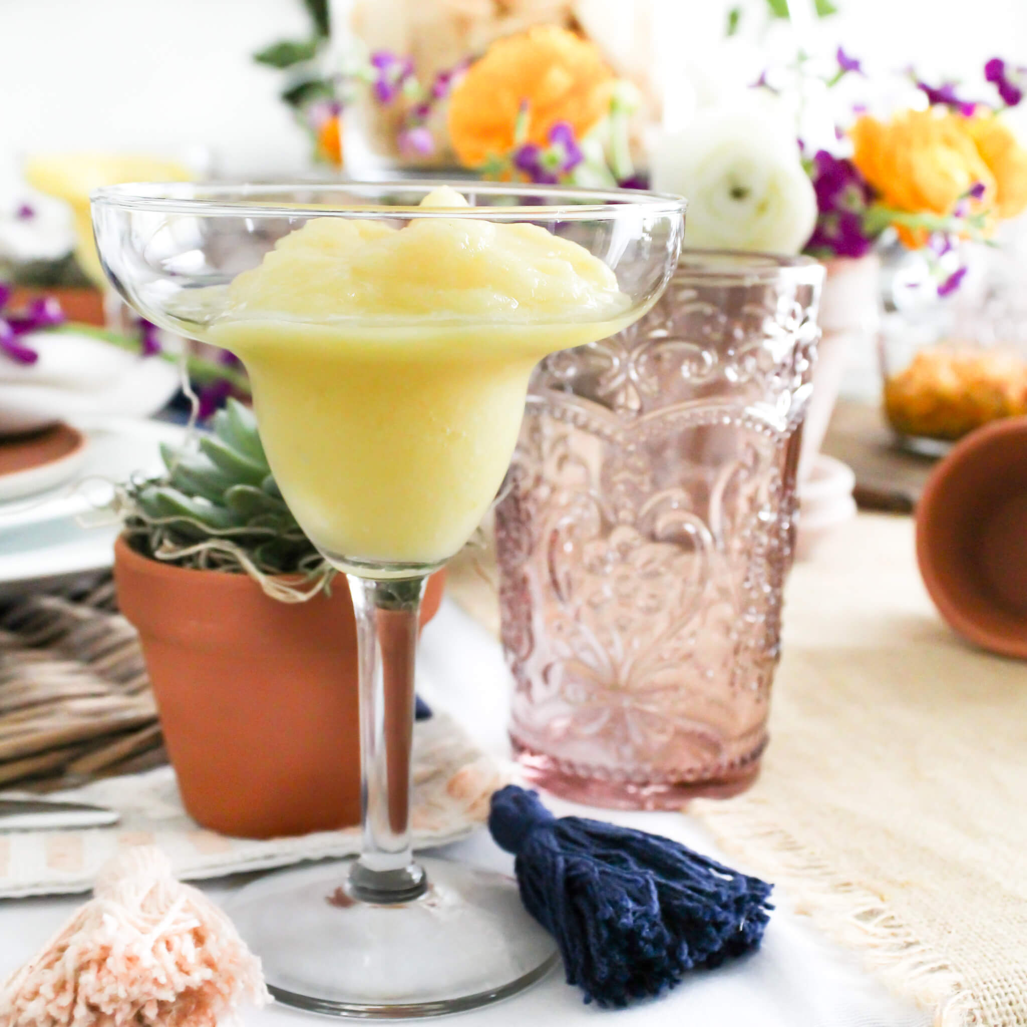 Frozen Pineapple Margarita set on a dining room table decorated for a festive Cinco de Mayo party