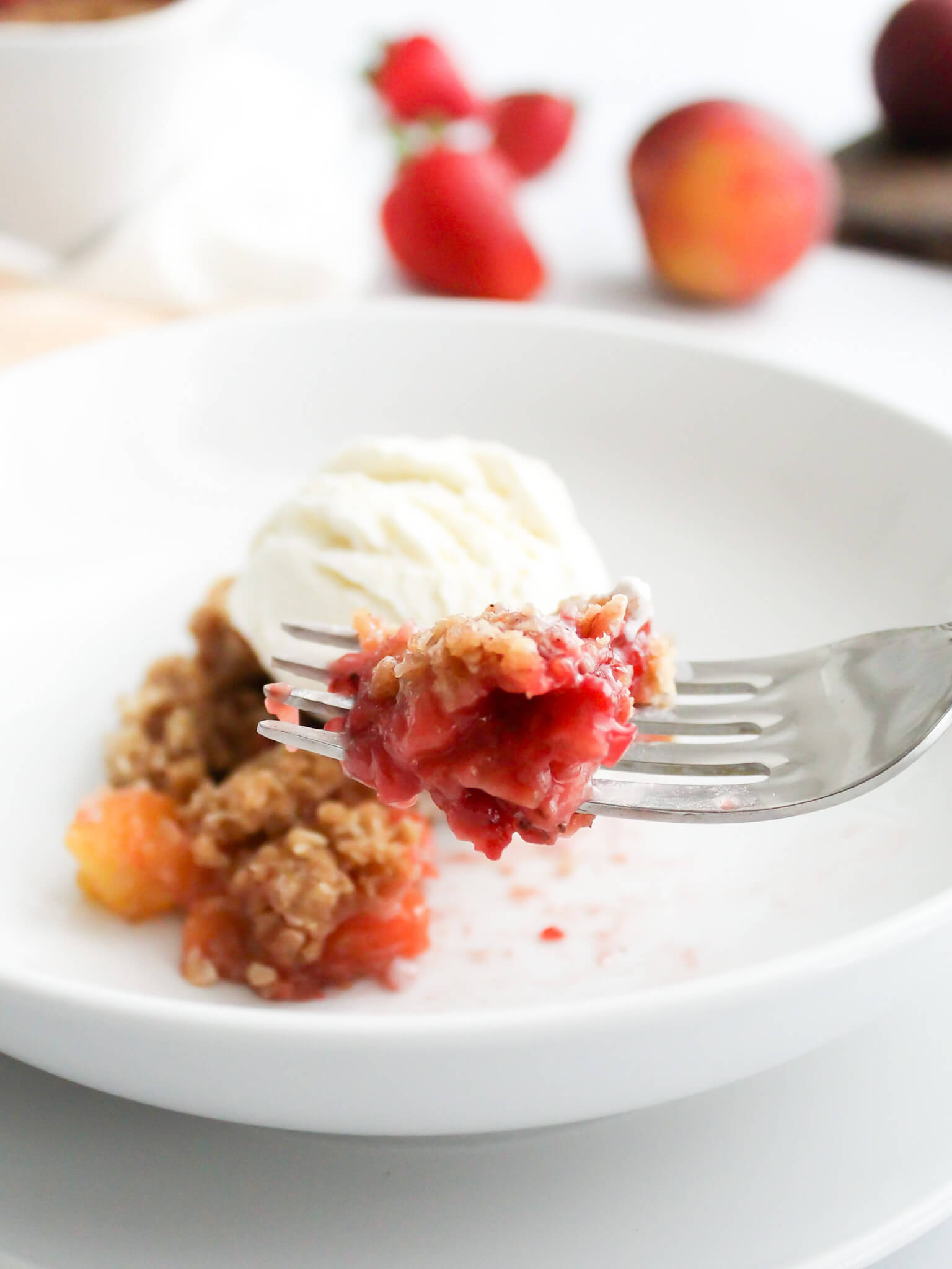 Close-up view of Bite of Strawberry Peach Crisp on a Fork