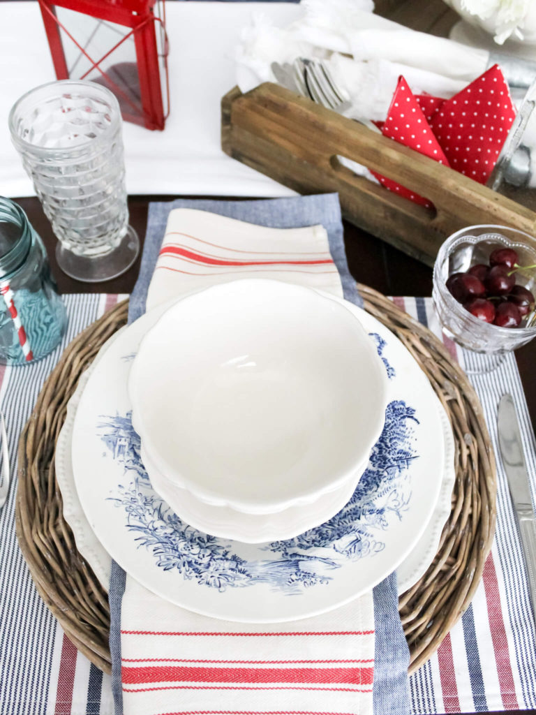 4th of July place setting styled with patriotic-inspired red, white, and blue dishes and napkins