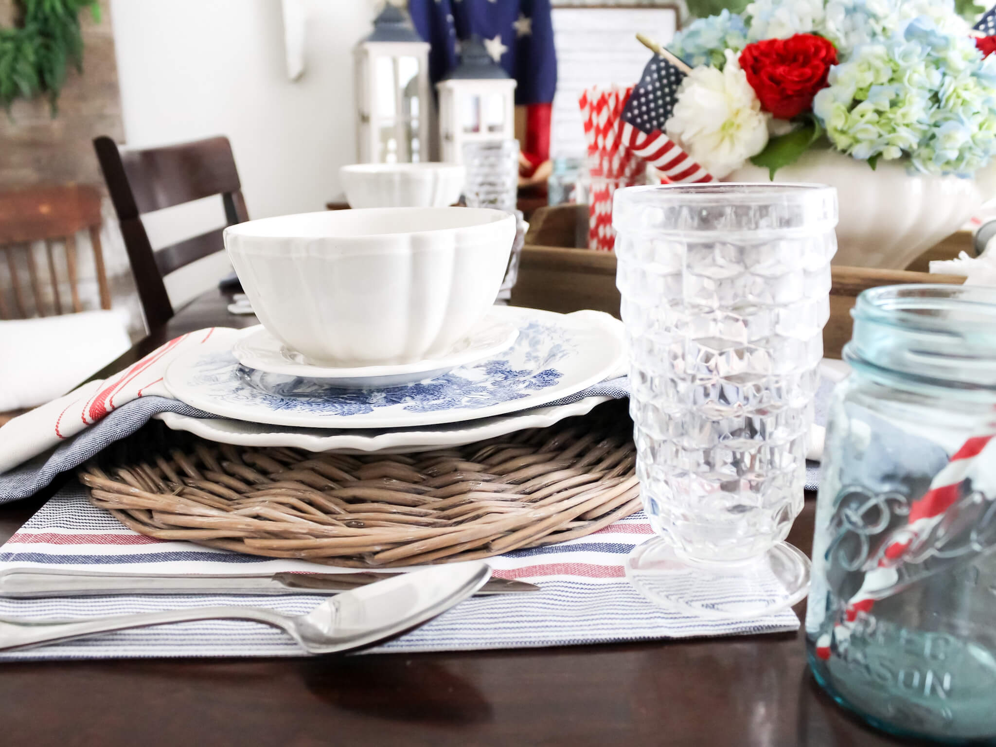 Patriotic 4th of July Tablescape with red white and blue flower centerpiece and blue transferware dishes 