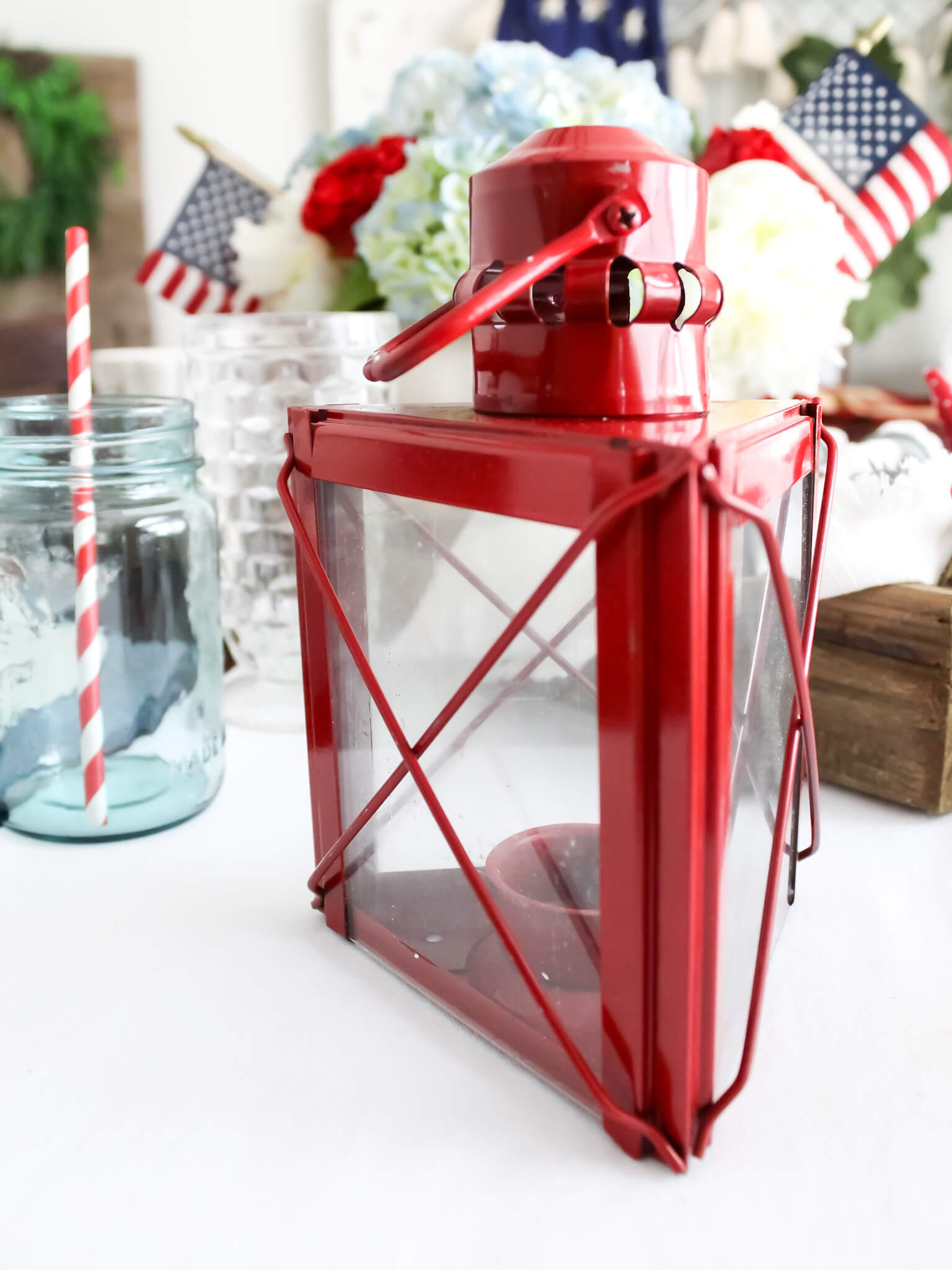 Small red lantern decor styled on a patriotic table for the Fourth of July