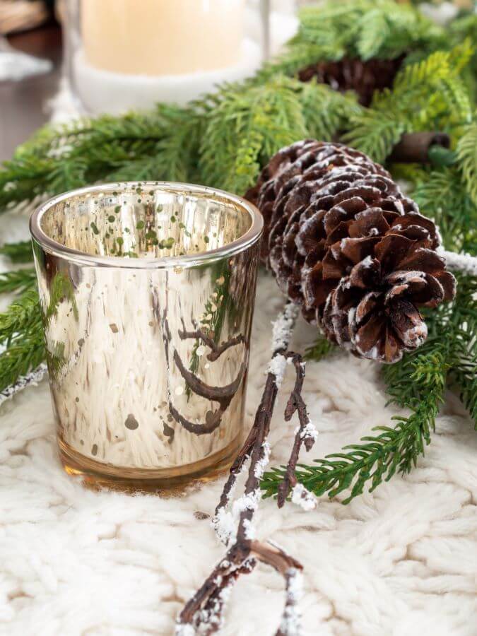 Details of  Winter Wonderland Tablescape with Christmas Garland and Mercury Glass Votive Candle  Holders