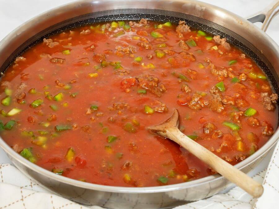 Adding the spaghetti sauce and water to the skillet lasagna - Midwest Life and Style Blog