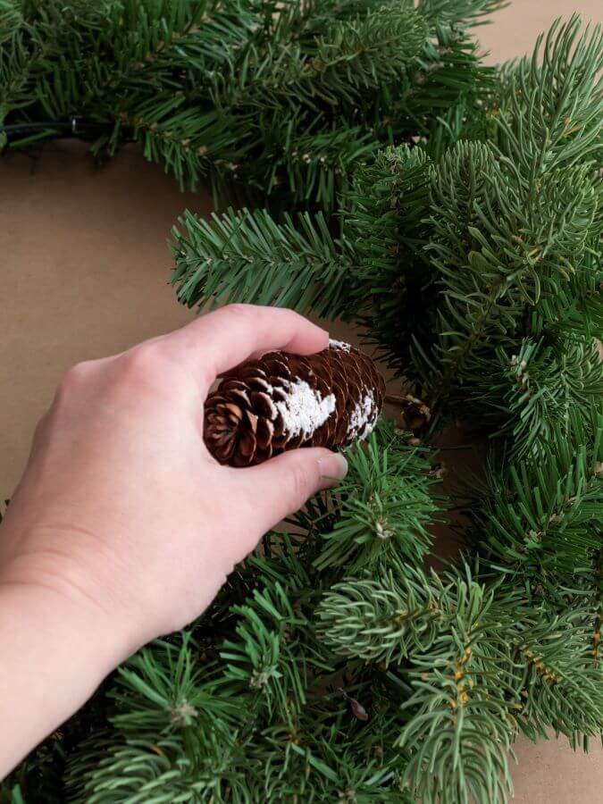 Adding pinecones to the wreath - Midwest Life and Style Blog