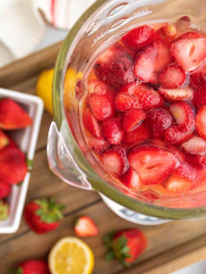 Strawberries and ingredients in the Blender for Spiked Lemonade