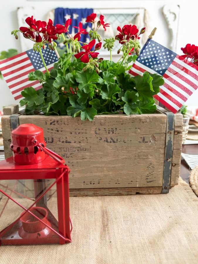 Patriotic Summer Centerpiece with Red Geraniums and American Flags in a Vintage Wood Crate