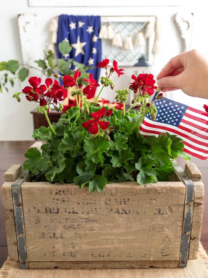 Adding American Flags to a Wood Planter filled with Red Geraniums