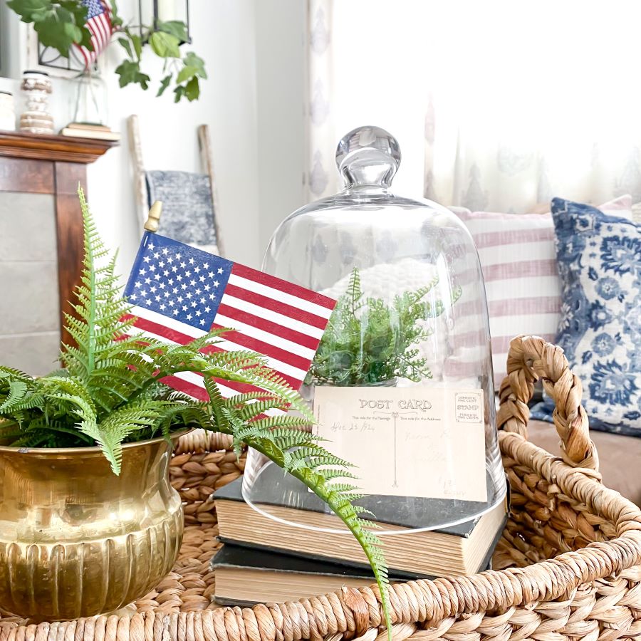 Vintage patriotric display with American flag, brass planter, and class cloche in a straw serving basket - Midwest Life and Style Blog