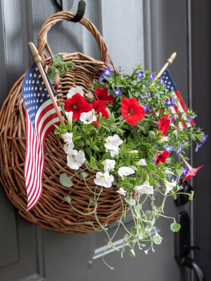 Patritotic Summer Door Basket Decorations with Red, White and Blue Annuals and American Flags Hanging on the Front Door