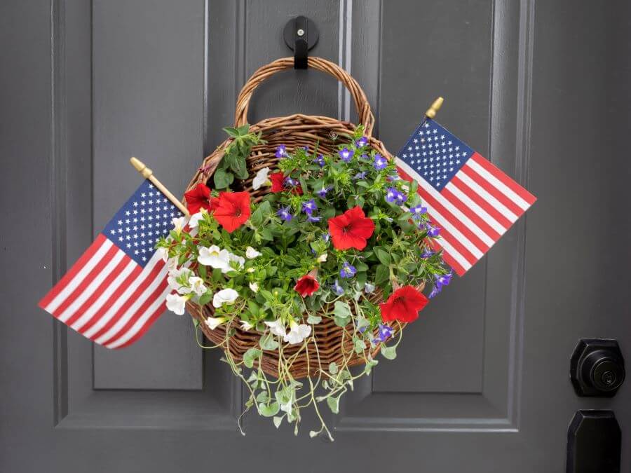 Patritotic Summer Door Basket Decorations with Red, White and Blue Annuals and American Flags Hanging on the Front Door