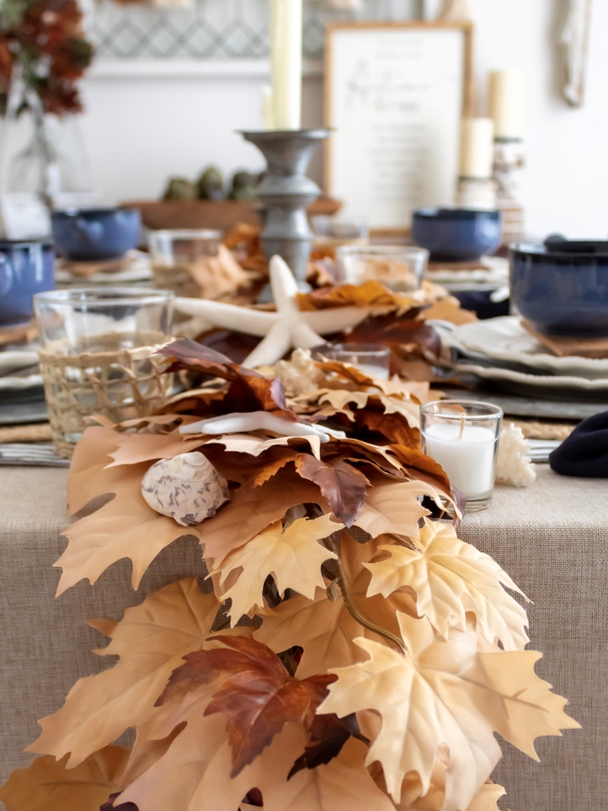 Close up view of fall leaf and seashell garland centerpiece for a coastal table setting