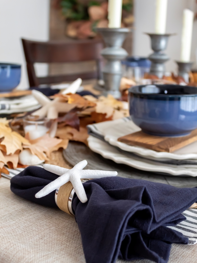 DIY Coastal Napkin Ring  wrapped around a navy napkin on a coastal fall tablescape