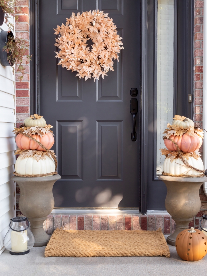 Stacked Pumpkin Topiaries Displayed in Urns on a Front Porch for Fall