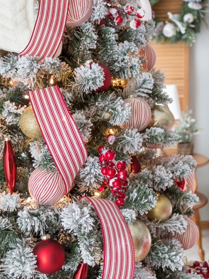 Close up view of frosted berry picks used to decorate a flocked Christmas tree