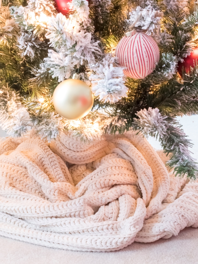 Using a knit blanket as a tree skirt to cover up a tree stand