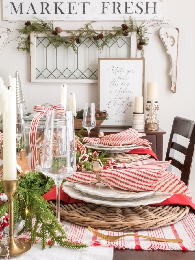 Farmhouse style dining room decorated for Christmas with red and white decorations and a gingerbread theme tablescape