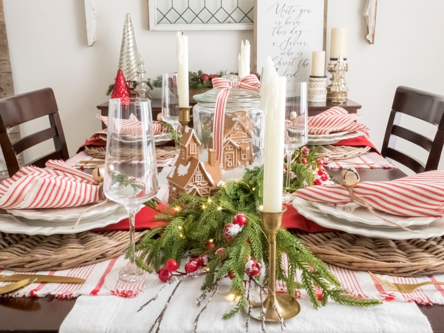 Whimsical gingerbread holiday table with red and white Christmas decorations and gingerbread houses