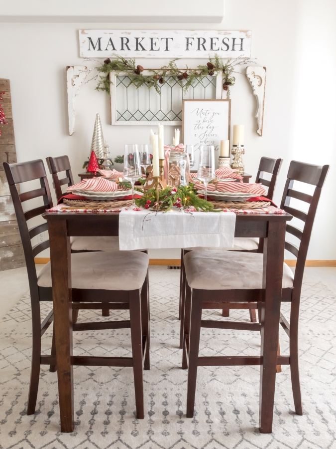 Farmhouse style dining room decorated for Christmas with red and white decorations and a gingerbread theme tablescape