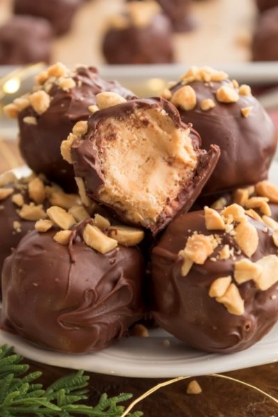 Chocolate Covered Peanut Butter Balls on a plate with a bite taken out of one of the PB balls