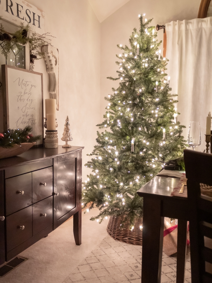 Christmas tree in a dining room lit up at night 