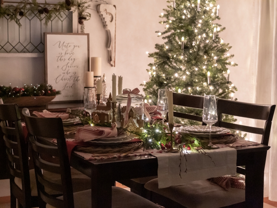 Dining room decorated for Christmas and lit up at night by the glow of a Christmas tree