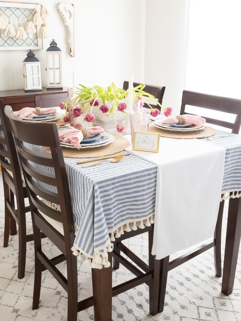 Pink and blue tablescape set for a Mother's Day Luncheon with pink floral centerpiece