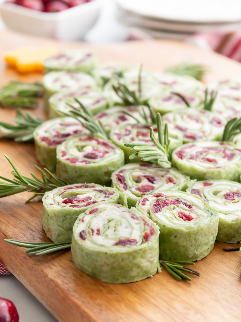 Cranberry and feta spinach pinwheels  Christmas appetizer arranged on a display board in the shape of a Christmas tree.