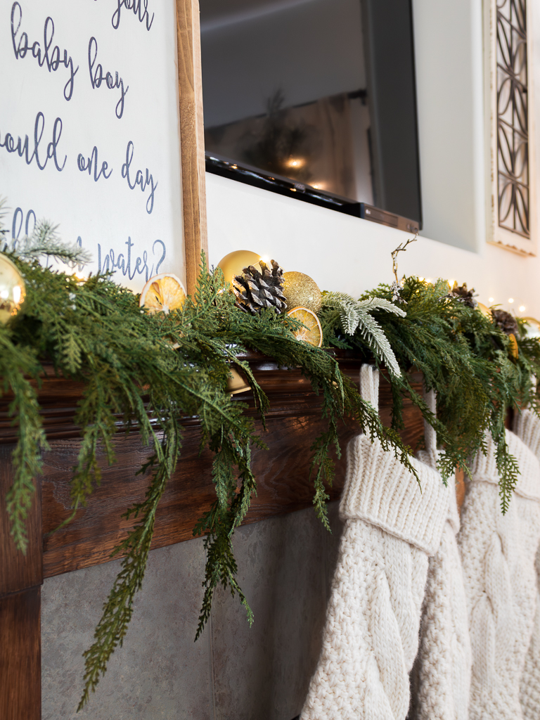 Christmas mantel in living room with greenery and dried oranges