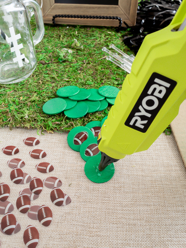 Gluing football decorations onto drink stir sticks