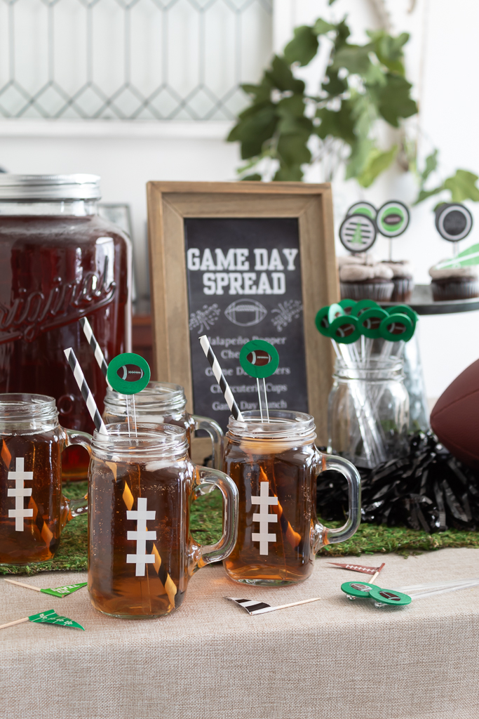 Drink station for a Super Bowl watch party with football mugs and DIY drink stir sticks