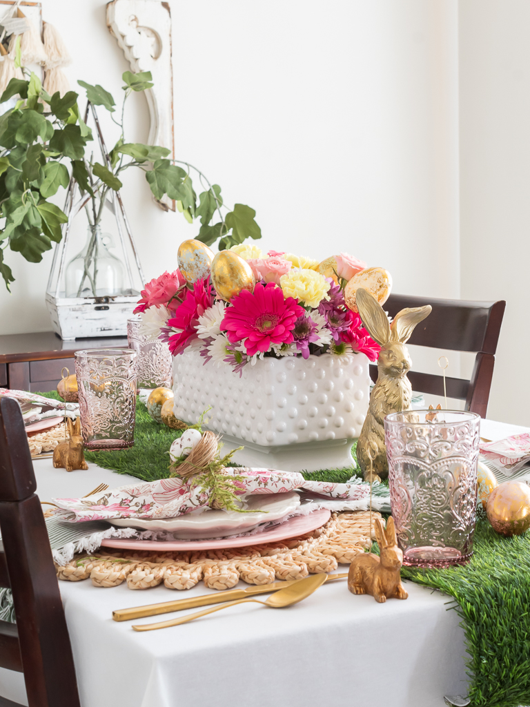 Colorful Pink and Table Setting for Easter Brunch with a Flower Centerpiece with Easter Eggs, Gold Bunnies, and DIY Easter Napkin Rings