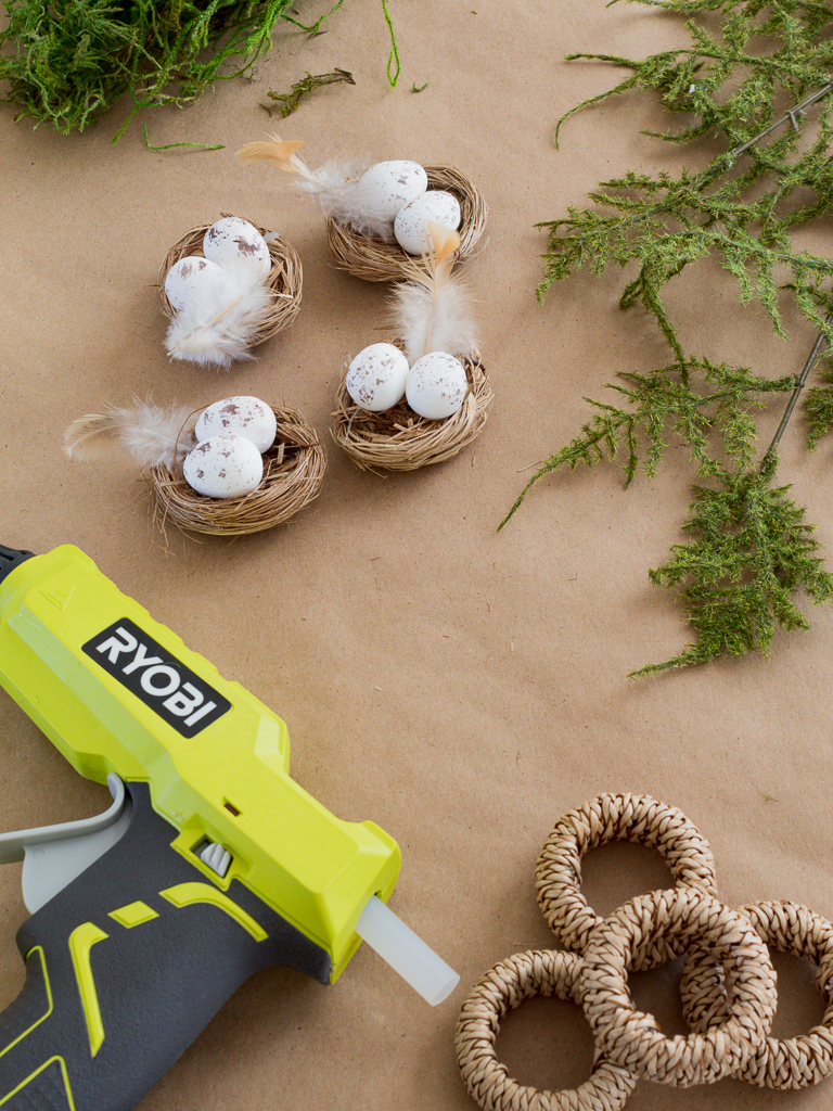 Glue Gun, Mini Bird's Nests, Napkin Rings and Greenery to Make DIY Easter Napkin Rings