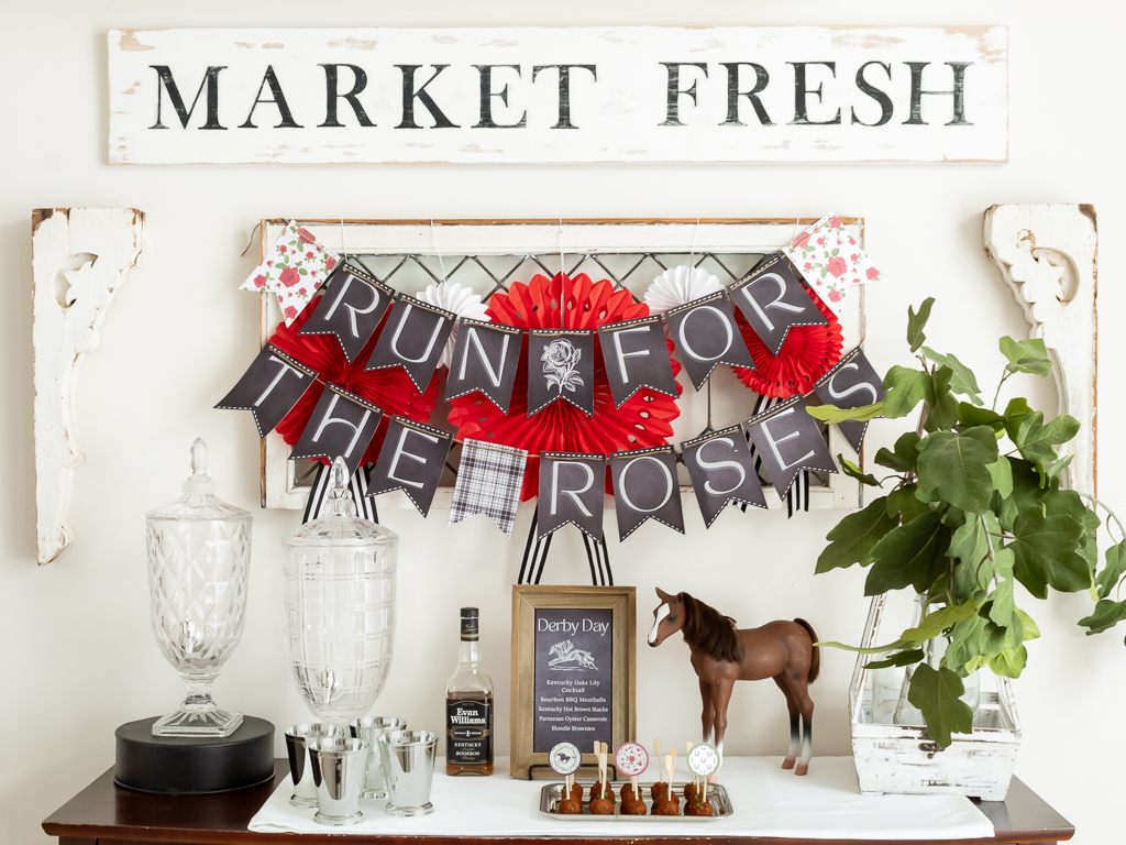 Buffett table set with appetizers and cocktails for a horse-themed Derby party with a printable "Run for the Roses" banner hanging above the food