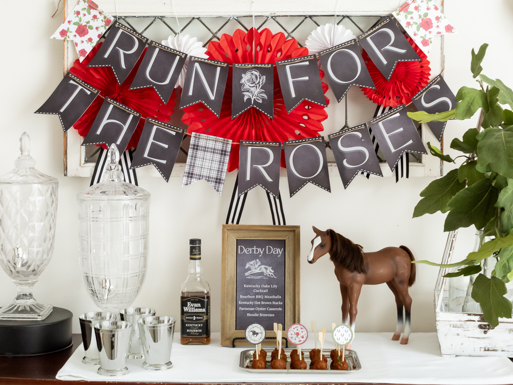 Buffett table set with appetizers and cocktails for a horse-themed Derby party with a printable "Run for the Roses" banner hanging above the food