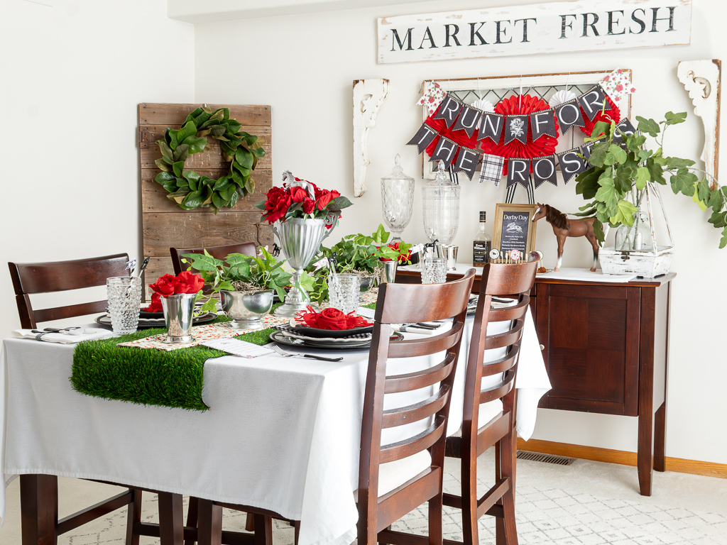 Full view of dining room table and buffett area decorated for a Derby party with red and black Kentucky Derby decorations and free Kentucky Derby printables including a banner and menu