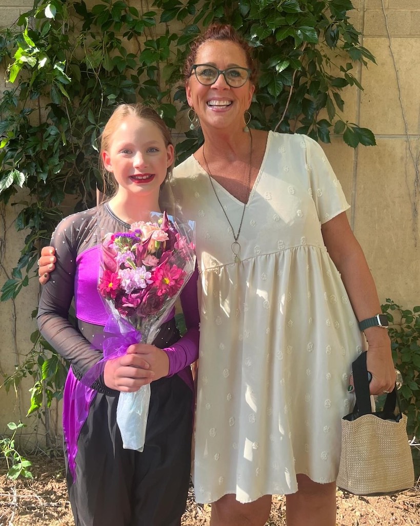 grandma with granddaughter holding a bouquet of flowers after a dance recital