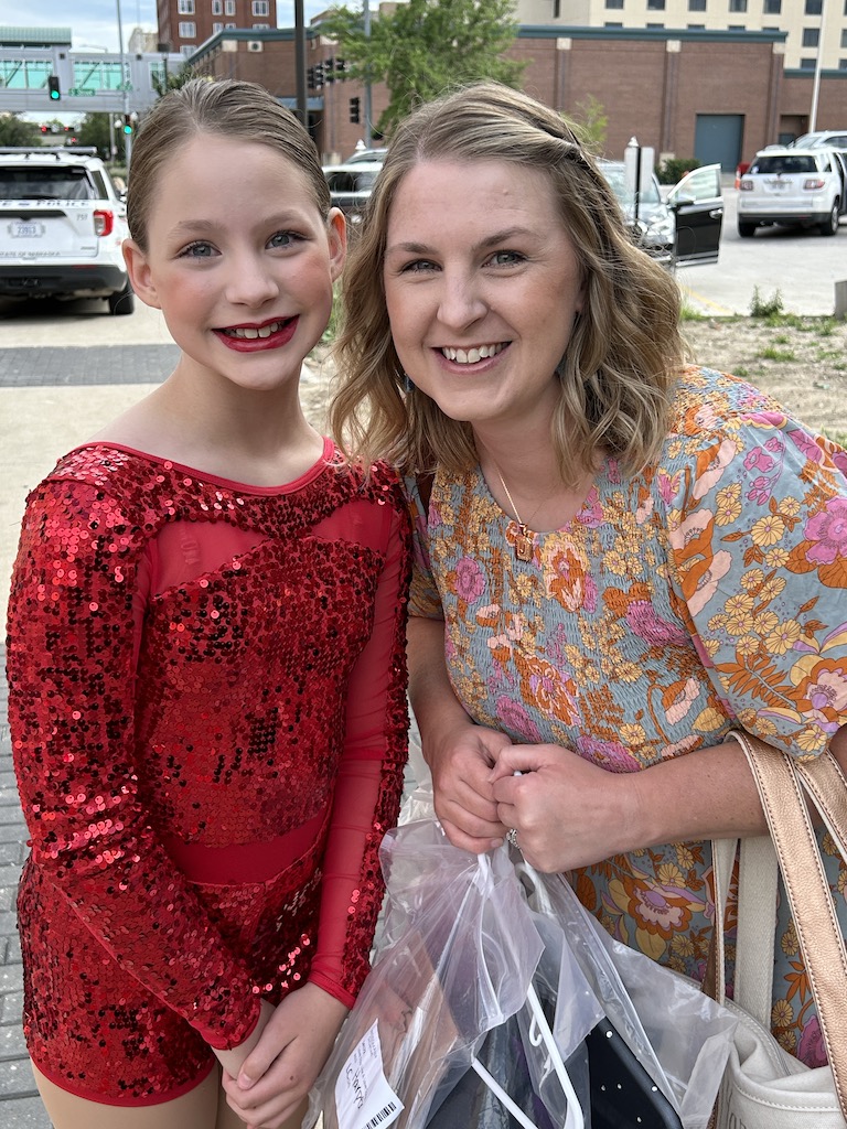 mom with daughter smiling before a dance recital