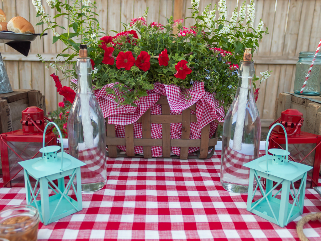 red and white summer flower centerpiece in a picnic basket with red and white checked fabric 