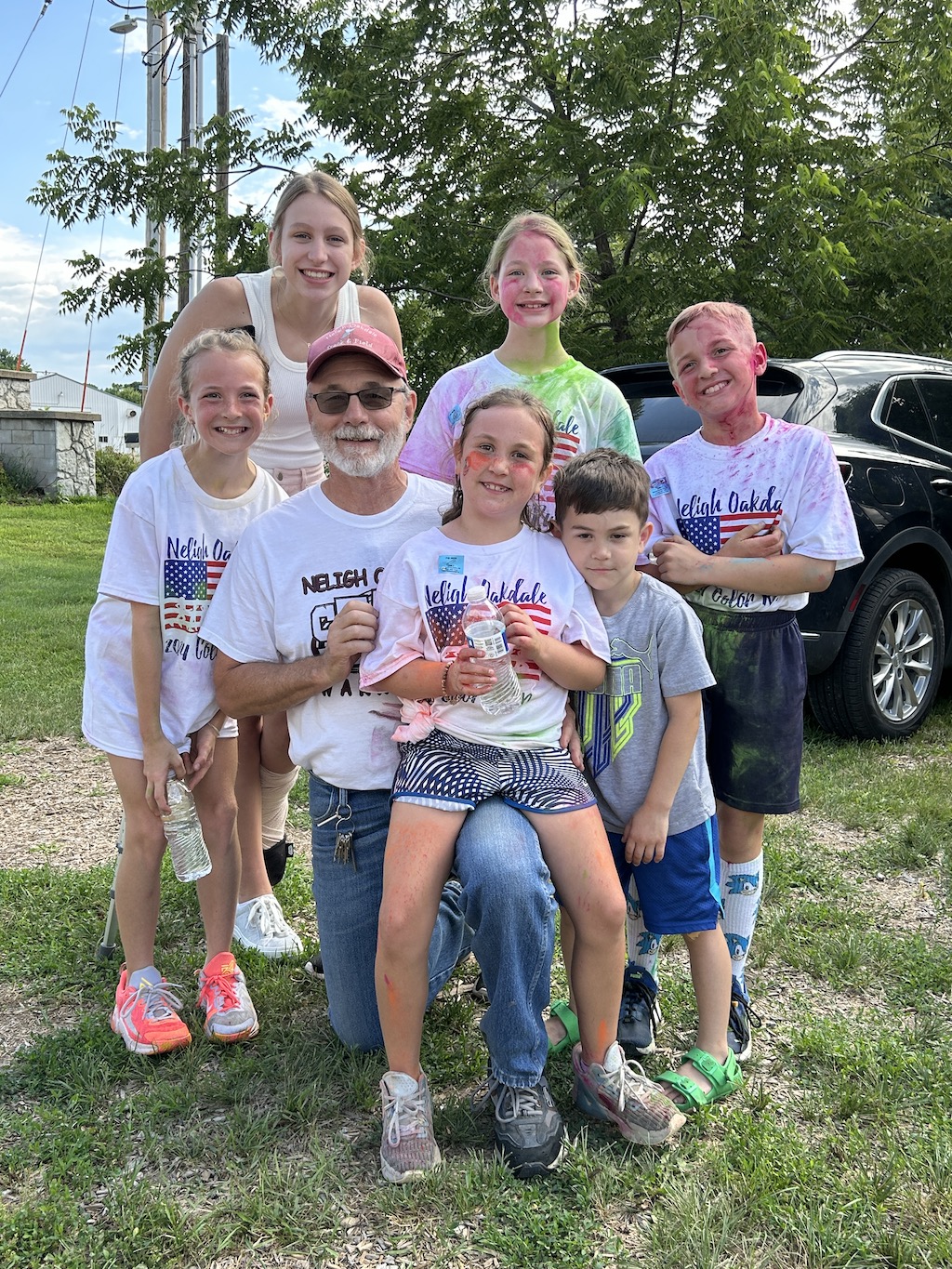 Grandpa with all of his grandkids after a 5k color run