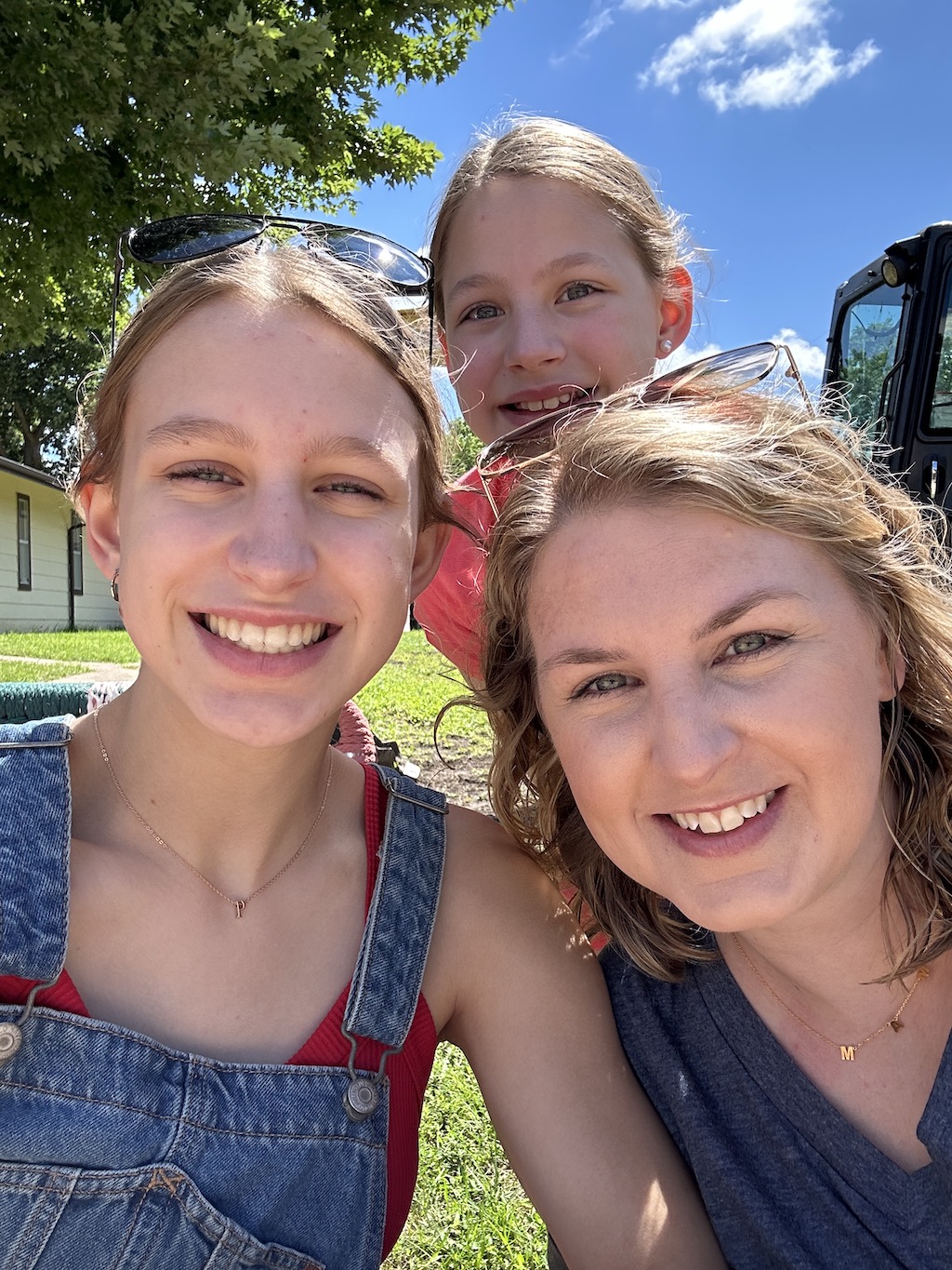 Mom and daughters smiling at the 4th of July parade