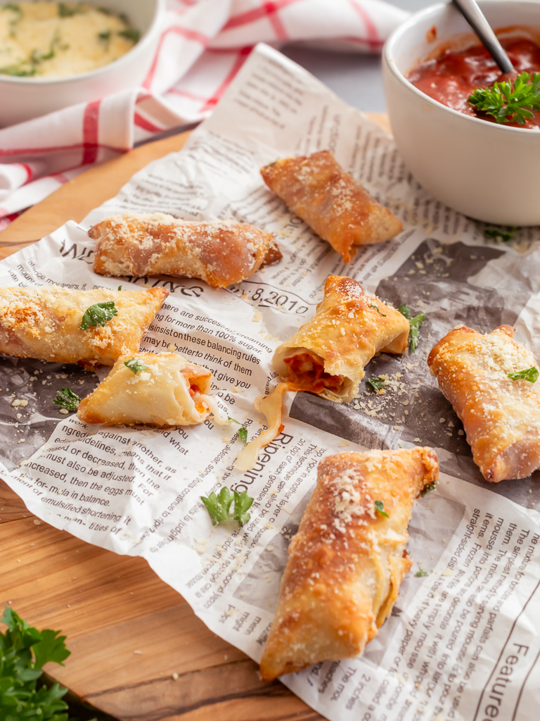 Homemade pizza rolls torn open to see pepperoni and cheese filling