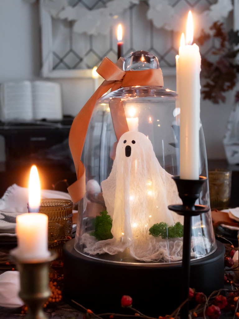 DIY ghost under a cloche as a centerpiece on a Halloween tablecape