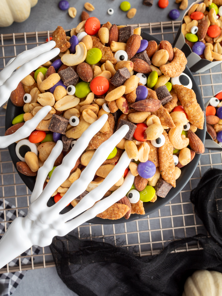 Overhead view of Halloween Monster Munch Trail Mix with skeleton hand serving utensils